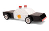 The Candylab Police Cruiser is a wooden toy police car crafted from solid beech wood, featuring a black body, a white roof, and a yellow sheriff star on the side. It has four rubber tires with "CANDYLAB" written on them and two red lights on top. The car is photographed against a plain white background and is safety tested.