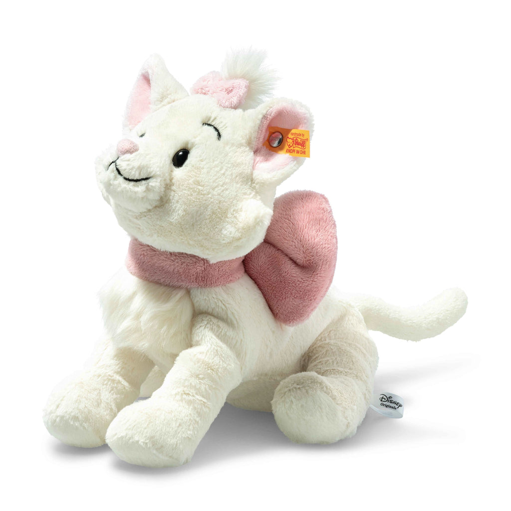 A young girl with light brown hair, wearing a long-sleeved pink shirt and beige pants, is sitting and hugging a Steiff, Disney's "Aristocats" Marie Cat Plush Stuffed Toy, 9 inches. She is looking down at the toy with a gentle and affectionate expression. The background is neutral and softly lit.