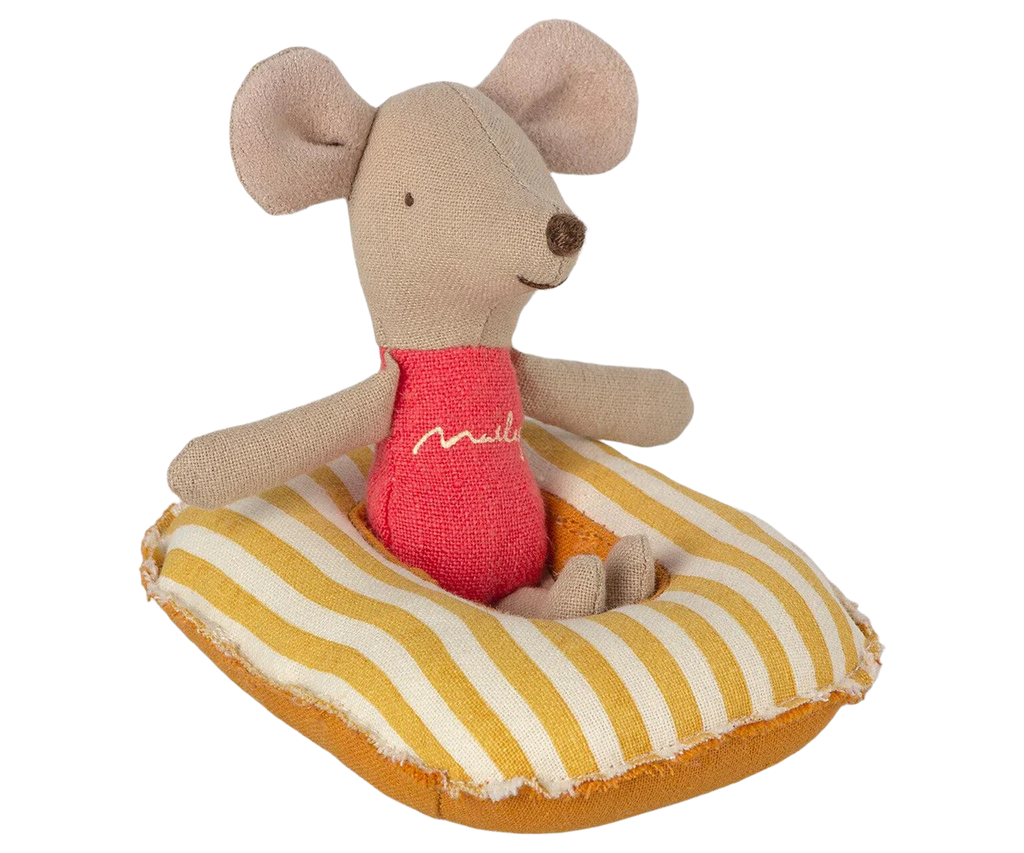 A small fabric toy mouse with beige fur is seated on a Maileg Beach Raft, Small Mouse - Yellow Stripe. The mouse is wearing a red shirt with the word "mail" embroidered on it. The mouse's features are simple, with black eyes, a stitched smile, and large rounded ears like those of baby mice.