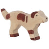 A handcrafted wooden Holztiger Farm Dog with a simple, rustic design. The light brown dog, adorned with darker brown spots and a slightly raised tail, features minimalistic details like two small black eyes and a slightly smiling mouth. This high quality "Made in Europe" piece reflects the charm of HOLZTIGER figures.