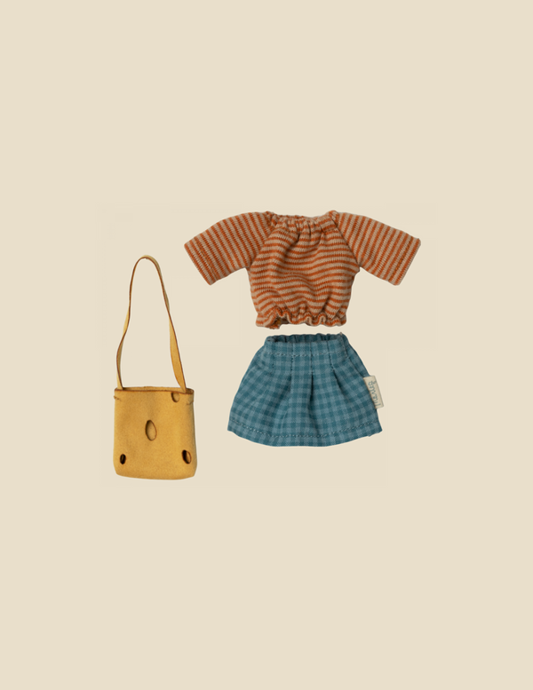 A Maileg Extra Clothing: Clothes For Mum Mouse featuring an orange and brown striped short-sleeve top paired with a blue plaid skirt. A small yellow cheese hole bag with two front pockets is placed next to the ensemble. The background is a plain off-white color.