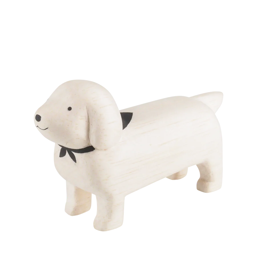 A small, handcrafted wooden figurine of a dog with a minimalist design. Made from hand-carved soft light wood, the Handmade Tiny Wooden Animals - White Dachshund Dog features a smooth surface, black nose and eyes, and a black bandana around its neck. Its tail is short and upright—an exquisite creation by skilled artisans.