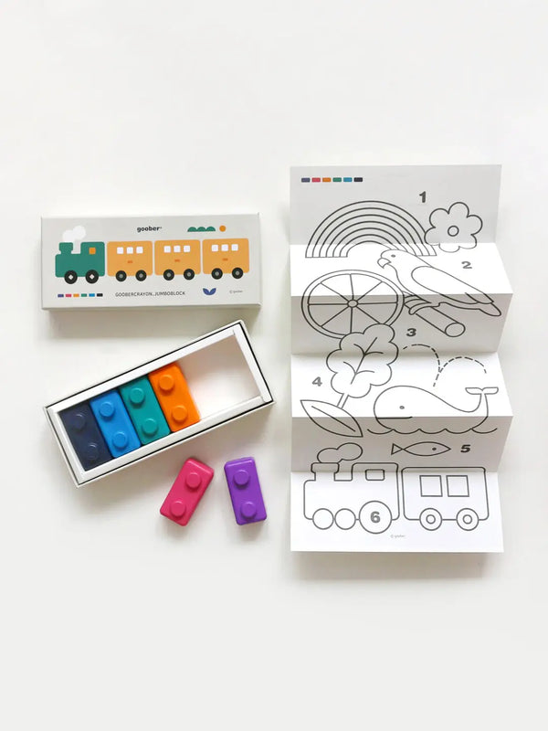 A set of coloring pages with outlines of images like a rainbow, bird, leaf, whale, and train is accompanied by a box of non-toxic **Jumbo Block Crayons** in various colors (blue, orange, green, red, purple). The packaging features a train illustration ideal for fine motor skill development.