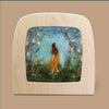 A felt artwork features a figure in a brown dress set against a whimsical, colorful backdrop of vines and foliage, evocative of the "Silhouette Only - Whispers of Spring" design. The scene is encased in a translucent material and framed with light wood.