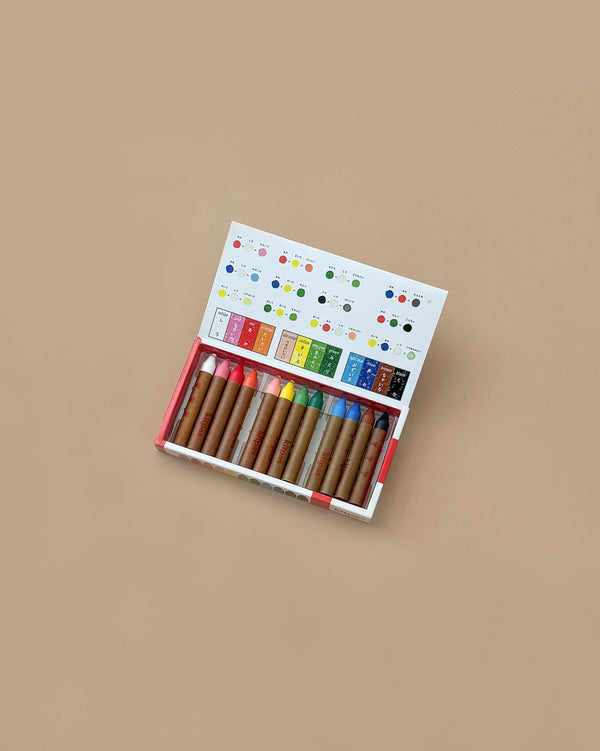 A box of Kitpas Crayons - 12 Colors displays a vibrant color chart on the lid, with various shades neatly arranged inside on a beige background. These non-toxic crayons are ideal for safe and creative fun.