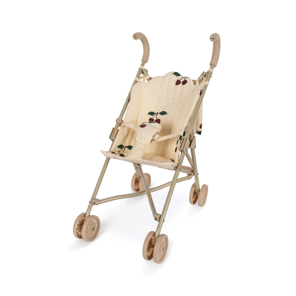 A Konges Sløjd Doll Stroller - Glitter Cherry with a cushioned seat featuring a cherry pattern. The stroller has double brown wheels and a beige frame with curved handles. It is designed for children to play with dolls or stuffed animals, and the fabric is removable for easy cleaning.