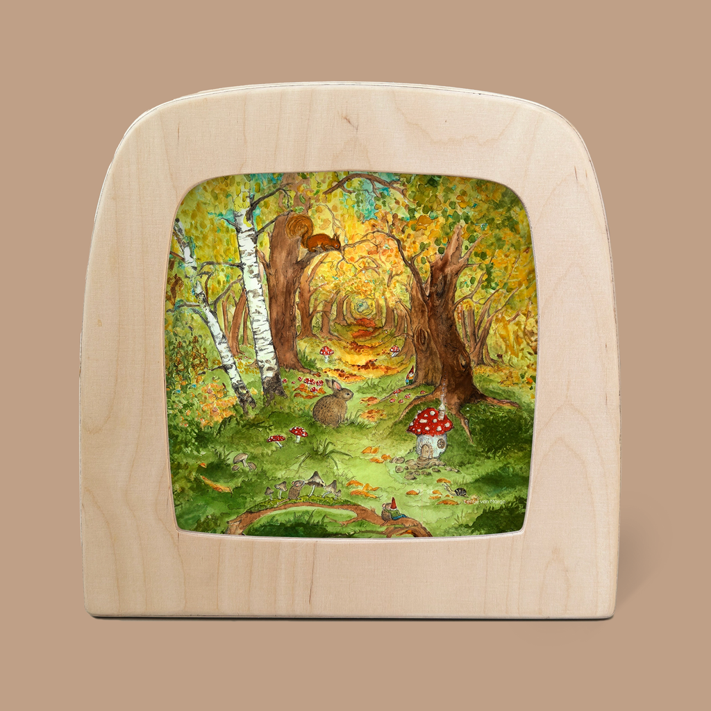 A whimsical depiction of an autumn forest scene, designed exclusively as a silhouette for the Toverlux Lamp. The artwork showcases colorful trees, a hedgehog, mushrooms, a fox peeking from behind a tree, and a vibrant green path. Shipping is available in approximately one week.