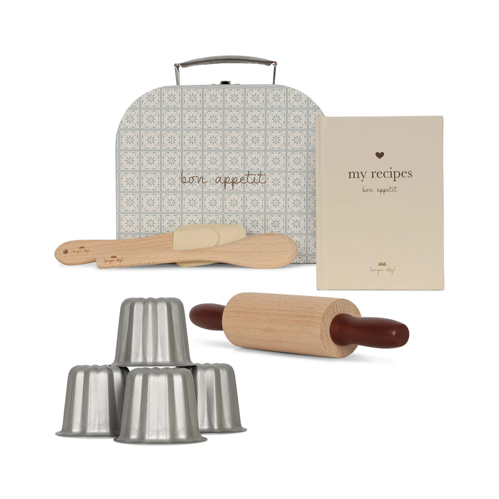 A cooking set perfect for tiny bakers, featuring baking tools including a wooden rolling pin, a spatula, a wooden spoon, five metallic baking molds, and a recipe book titled "My Recipes," all neatly stored in a patterned blue and white storage box labeled "Madeline Baking Set - Petite Cousine.