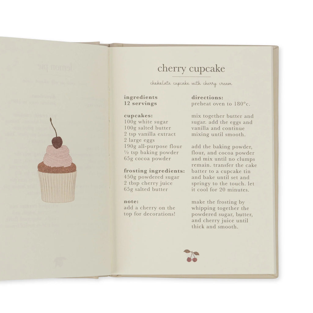 An open cookbook displays a recipe for cherry cupcake with cherry cream, perfect for tiny bakers. The text includes ingredients, directions, and a small illustration of a cupcake topped with a cherry. The page is neatly formatted with clear sections for easy reading, just like the rest of your **Madeline Baking Set - Petite Cousine** in the kitchen.