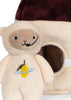 A Teddy in Outer Space Stuffed Animal - Rocket, featuring an embroidery of a lemon with a blue ring on its chest and filled with recycled polyester, stands in front of a plush object resembling a small house with a circular doorway and a maroon roof. The plush toy bear has beige fur, a smiling face, and black stitched features.