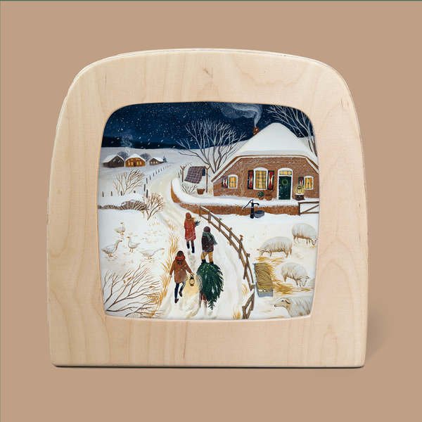 Presenting the "Silhouette Only - December for Toverlux Lamp": A wooden-framed artwork featuring an enchanting snowy village scene at night. Three mystical silhouettes meander along a snow-covered path heading towards a cozy house, warmly aglow from within. The landscape is elegantly enveloped by snow-draped trees and fields, all under a starry sky that enhances its magical ambiance. Ships in approximately one week.