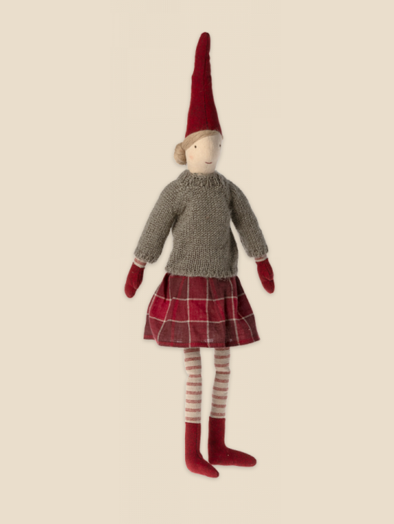 Introducing the Maileg Christmas Pixy (Size 3), a fabric doll dressed in a gray knit sweater, red and white striped tights, a red and white plaid skirt, and red mittens. The doll is also adorned with a tall red pointed hat and has simple facial features with a neutral expression. Made from exclusive materials, it embodies the perfect Christmas decoration with pixie charm.