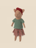 Standing against a plain beige background is a charming Maileg Christmas Pig - Girl. This soft toy, with its whimsical flair and minimalist features, wears a red beret, a knitted green sweater, and a red plaid skirt—perfect for adding festive cheer to your holiday décor.