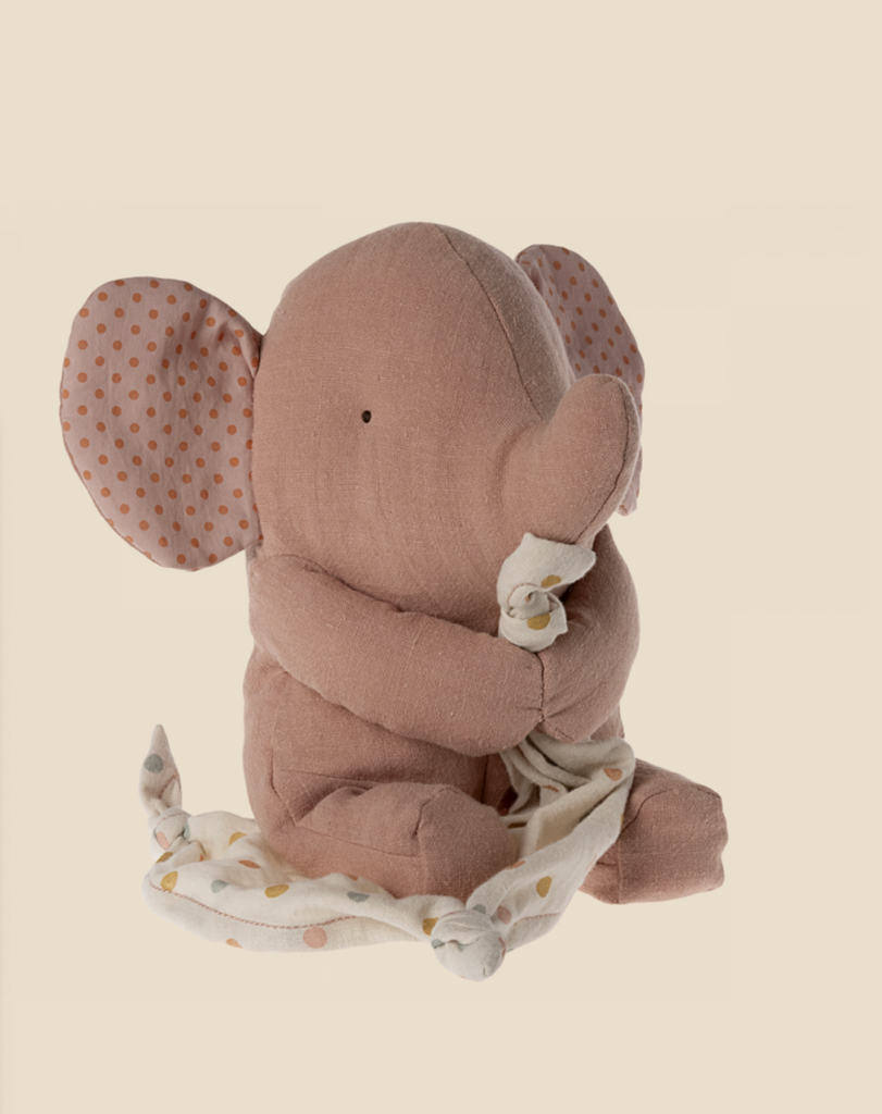 A Maileg Lullaby Friends - Elephant - Old Rose (Plays Music) with large polka-dotted ears sits holding a white and yellow polka-dotted blanket. The elephant's body and blanket are both made of fabric, giving it a cozy and cuddly appearance. Perfect for a baby gift box, it also fits beautifully into any Lullaby Friends collection.