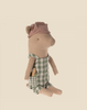 A Maileg Pig - Boy resembling the sweetest pig, wearing a green checkered outfit with a cross-stitched pocket. The boy pig also sports a pink and white striped hat. It is seated against a plain beige background, inviting you to create your own pig family.