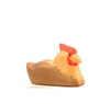 Introducing the Ostheimer Hen Brown On Nest, a small handcrafted wooden chicken figurine featuring a beige body, orange beak, and red comb. Depicted in a sitting position with a simple, rustic design perfect for imaginative play, this charming figure is inspired by Ostheimer toys and is set against a plain white background.