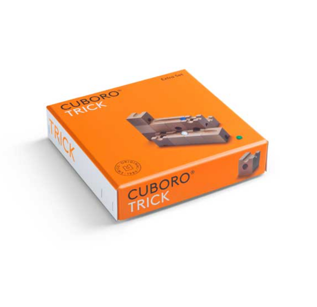 The image shows an orange Cuboro Trick Marble Run Extra Set box, featuring a cubic marble run system extension set. The front of the box displays the product name and a picture of a wooden marble track setup with marbles, perfect for developing fine motor skills. The Cuboro logo and product information are also visible.