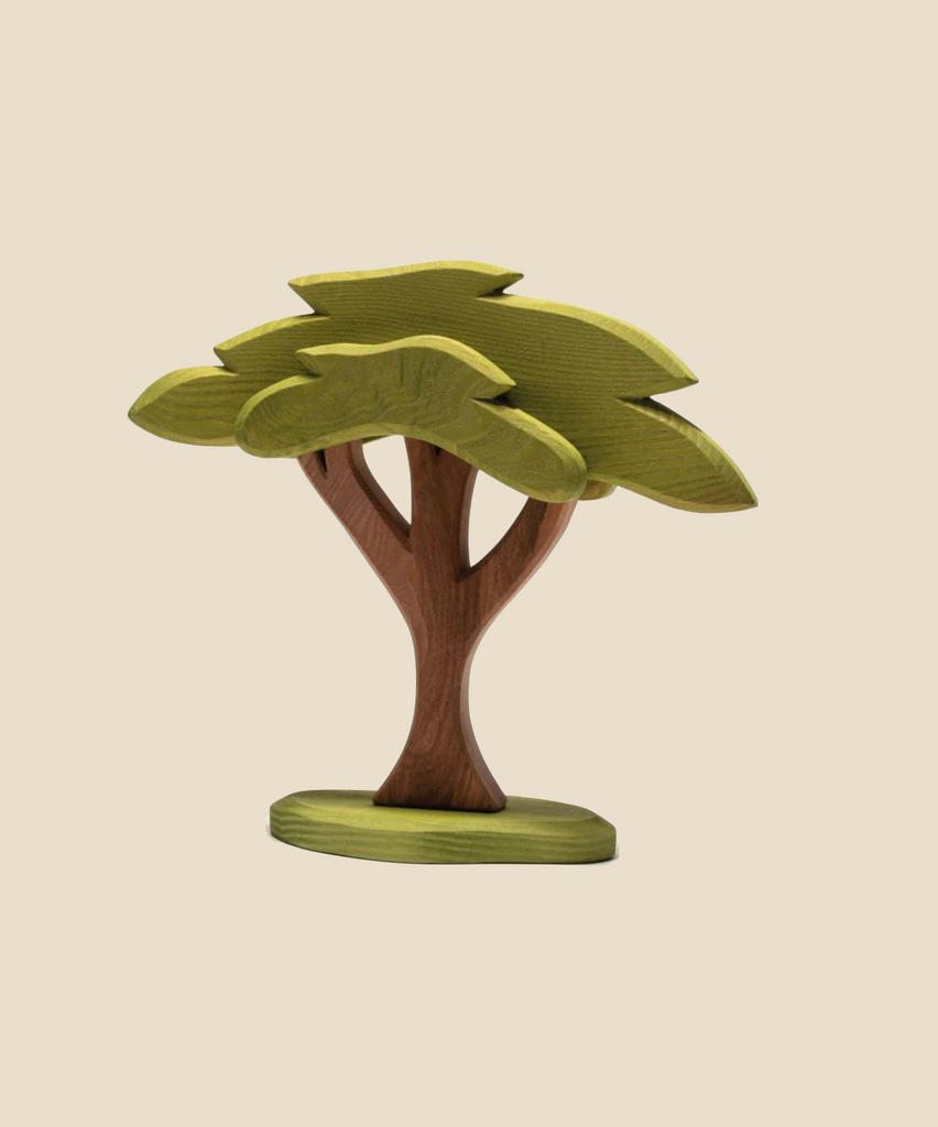 An Ostheimer African Tree, handcrafted from wood and featuring a green leafy stem, reminiscent of Ostheimer's exquisite wooden toys.