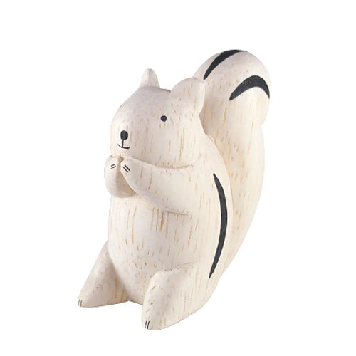 The Handmade Wooden Squirrel is a beautifully crafted figurine made from Albizia wood, featuring a light tan color with black streaks on its tail and back. Sitting upright with its front paws near its mouth, it radiates a relaxed, contemplative demeanor, showcasing the exceptional skill of Bali artisans.