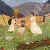 Three girls holding hands dance in a grassy meadow under a starry sky, their flowing dresses and flower crowns shining as magical silhouettes in the May Queen Dance for Toverlux Lamp. A flowering tree, mountains, and a bowl of flowers beautifully decorate the scene, while one girl holds an enchanting sun-shaped ornament with glistening ribbons.