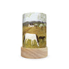 The Toverlux Lantern Shade Set - Robin Pieterse features a wooden base and displays an enchanting silhouette of a black and white horse leisurely grazing in a meadow. In the backdrop, you can see a charming house nestled amid trees and hills under a cloudy sky. This product ships in approximately one week.