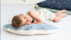 A young child lies on a Light Blue Stingray pillow on the floor, smiling at the camera, with a blue blanket in the background.