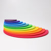 The Grimm's Rainbow Semi Circle Set consists of semi-circular wooden blocks, brilliantly arranged in a gradient of rainbow hues, transitioning from red on the outermost layer to purple at the center. Displayed against a white background, this extra-large creative puzzle is ideal for little architects and is beautifully stacked in a fan-like pattern.