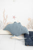 A plush Light Blue Stingray toy with a light blue texture, prominent eyes, and a tail, set against a simple backdrop featuring drawn seaweed and starfish.