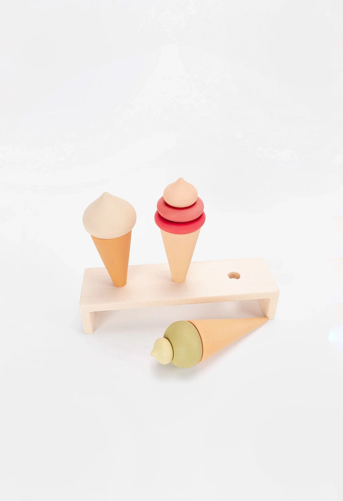 Two Handmade Ice Cream Cones and a toy popsicle, all coated with non-toxic water-based paint, displayed on a minimalist wooden stand against a white background.