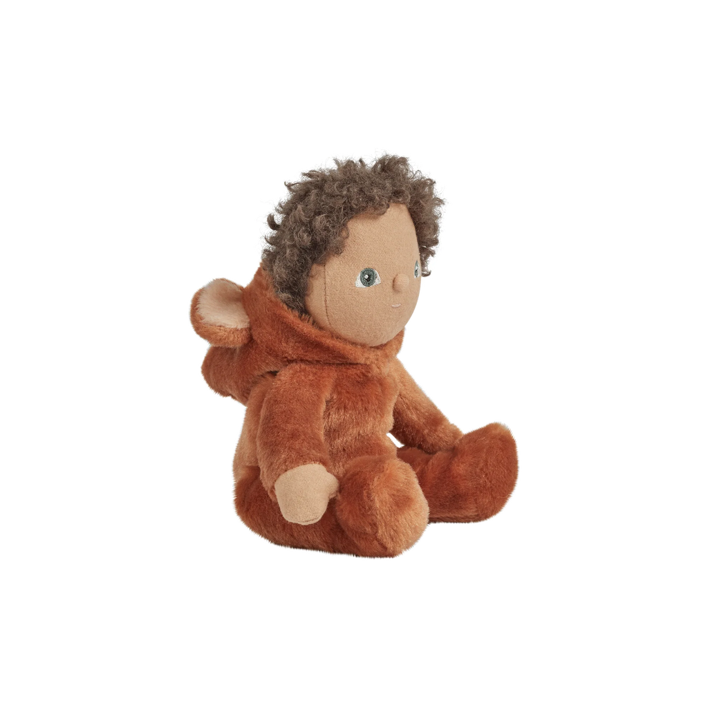 A plush doll with curly brown hair, blue eyes, and wearing a fuzzy, orange "Olli Ella | Dinky Dinkums Forest Friends - Bobby Bear" suit, sitting against a black background with white horizontal lines.