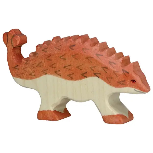 A wooden toy shaped like an ankylosaurus dinosaur. It is painted in earthy tones with a reddish-brown back and a cream-colored underside. The handcrafted wood toy features a rough, textured surface with triangular spikes along its back and tail, reminiscent of Holztiger figures.