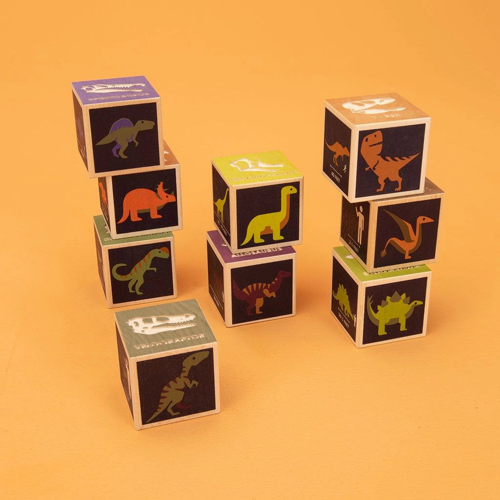 Stack of colorful Uncle Goose Dinosaur Blocks, placed on an orange background.