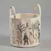 The Coral & Tusk Full Moon Masquerade Bucket, a fabric storage basket with two handles, features whimsical illustrations of animals in human clothing. Among them are a rabbit, a bear, a skeleton, and other characters parading under bare trees and the full moon in the background, evoking a charming Full Moon Masquerade.