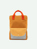 A rectangular orange Sticky Lemon Backpack Large | Farmhouse | Envelope | Homemade Honey crafted from waterproof nylon features two short orange handles. It has a front pocket with a flap; the main section of the pocket is light yellow and the flap is light gray with a white grid pattern secured by a snap button, embodying Sticky Lemon’s signature style.