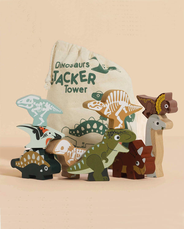 A set of vibrant, intricately painted Jurassic Stacking Dinosaurs, made from FSC-certified wood, is stacked beside a labeled fabric bag. These toys showcase various prehistoric species, bringing the dinosaur world to life with playful design.