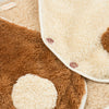 Close-up of the Meri Meri Puppy Costume's soft, fluffy sherpa fleece fabric in two shades: light beige and brown. The brown part features a large beige polka dot pattern, with a few buttons visible, suggesting it's an adorable piece of clothing with a textured, cozy design—perfect as a dog lover gift.