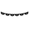 A black Meri Meri Bat Garland - Final Sale is strung across the image, featuring eight wing-like shapes evenly spaced along the length. Each shape appears to be made of a series of radiating thin lines, creating a stylish and symmetrical pattern reminiscent of paper bats.