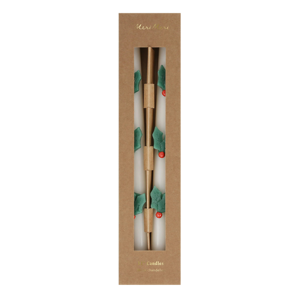 The MeriMeri Holly Table Candles (Set of 2) are exquisitely designed with green leaves and red berries. These Christmas candles come packaged in a sleek brown box with a transparent window, perfectly highlighting their festive design and adding a touch of traditional decoration to your holiday decor.