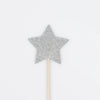 A silver glittery star attached to a thin wooden stick, set against a plain white background, resembling a wand. The star's upright and centered position makes it ideal for Meri Meri Wizard Party Hats & Wands - Final Sale.