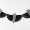 The Meri Meri Bat Garland - Final Sale, featuring black paper bats with folded, fan-like wings and small pointed ears, is a charming Halloween decoration that hangs strikingly against a white wall.