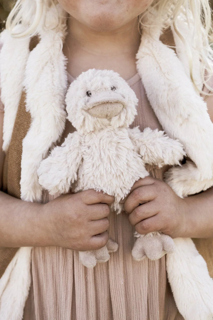 A girl holding the Mini Bill the Duck Rattle, perfect for babies and toddlers, sparks action-reaction learning with its built-in rattle.