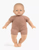 A Minikane Soft Body Doll (11") - Maé, dressed in a simple brown one-piece outfit, stands upright against a plain white background. Made from phthalate-free vinyl, this doll’s neutral facial expression and slightly outstretched arms invite imaginative playtime.