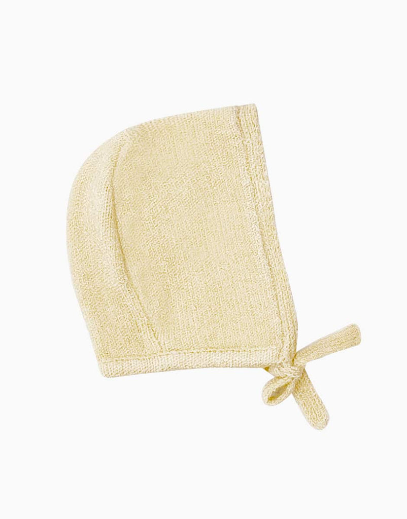 A light yellow, knit baby bonnet with a rounded crown and a tie closure under the chin, perfect for Minikane Babies, displayed on a plain white background.

Minikane Doll Clothing | Élie Cream Knit Bonnet