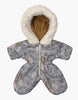 The Minikane Doll Clothing | Gigi Elaphe Ski Suit is a cozy, gray baby snowsuit reminiscent of a classic ski suit. It features a fluffy white hood lining and is adorned with a nature-themed pattern of deer and plants. It offers easy fitting with its front zipper and separated legs, echoing the design quality seen in outfits for Minikane dolls.