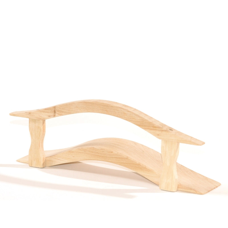 A small, light-colored wooden bridge with a simple, curved design. The bridge consists of two main arching planks connected by four vertical supports. Perfect for imaginative play with Ostheimer Bridge with Railing, its minimalist construction and natural finish give it an elegant and rustic appearance.