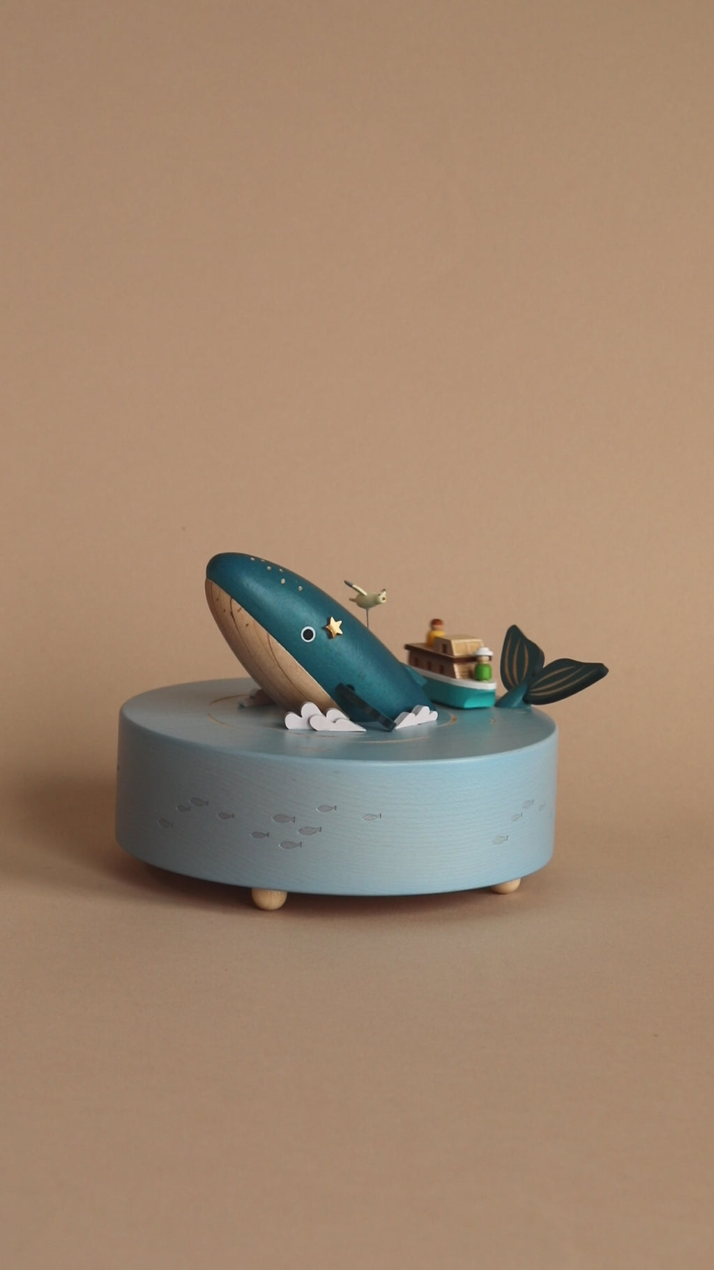 Wooden ocean themed music box with a blue whale in the center and a boat going around it. 