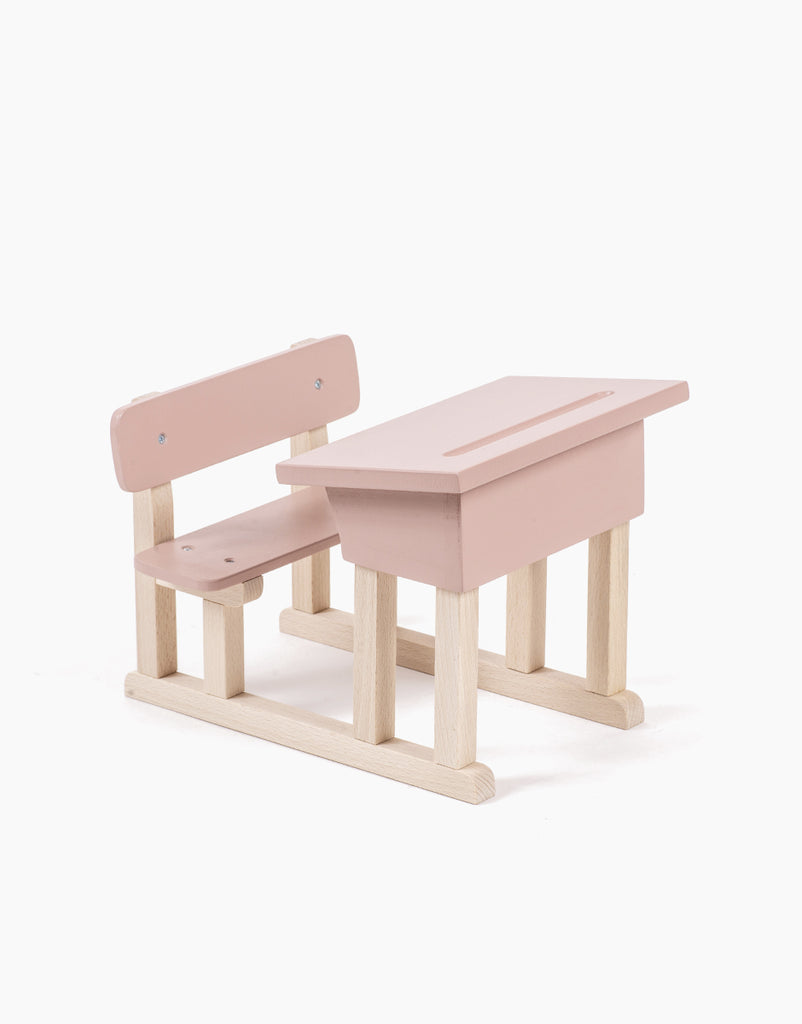 The Minikane Doll School Desk - Grey is a compact, artisan-crafted children's wooden school desk with an attached bench. The desk features a flat top with light wood legs, while the bench includes a backrest, all painted in a charming grey. The design is simple and perfect for playtime with Minikane Babies.