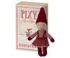 A small fabric doll dressed in a red and beige outfit stands next to a box labeled "Maileg Pixy Elfie." The doll has a red hat, red shoes, and a plaid dress with red suspenders. It's the perfect Christmas friend, and the box features a winter illustration of Maileg Pixy Elfie in a similar outfit.