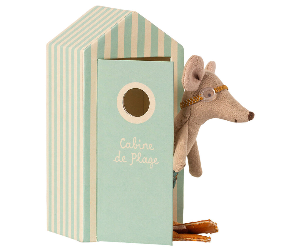 A small Maileg Beach Mouse - Big Brother wearing sunglasses peeks out of a mint-green and cream striped toy beach house cabana with a circular window. The cabana has "Cabine de Plage" written on the front, and the mouse, dressed in tiny swim trunks, also holds a pair of orange flippers.