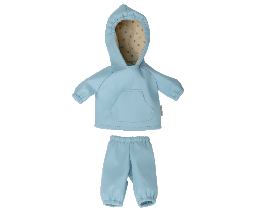 A small blue set from Maileg, featuring a hoodie with a polka dot inner lining and matching pants, specifically designed as extra clothing for Teddy Junior. Laid flat on a white background, this rainwear ensemble is perfect for keeping your doll or stuffed toy cozy.